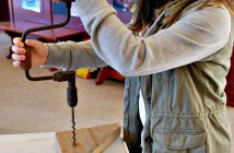 Kalei Huddlestone tries out a hand drill at the Heritage Hand Tools display at the Huntsville Train Station
