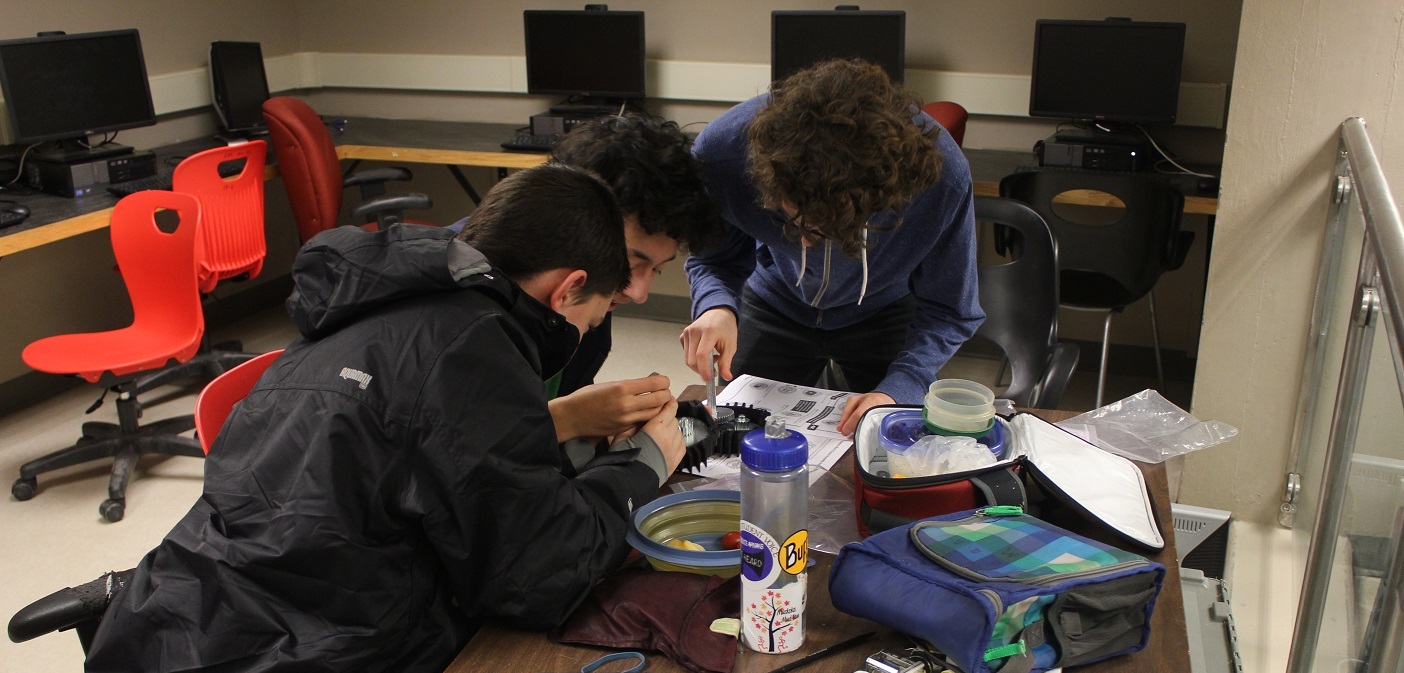 Cameron Gibson, Keegan Chan and Aidan McClung work on a component for Hoyas Robotics latest robot