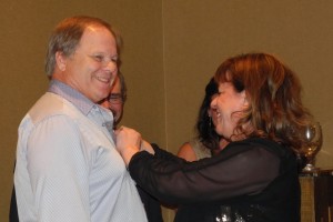 Jan Nyquist is "pinned" by Rotary District 7010 Governor Lise Dutrasic.