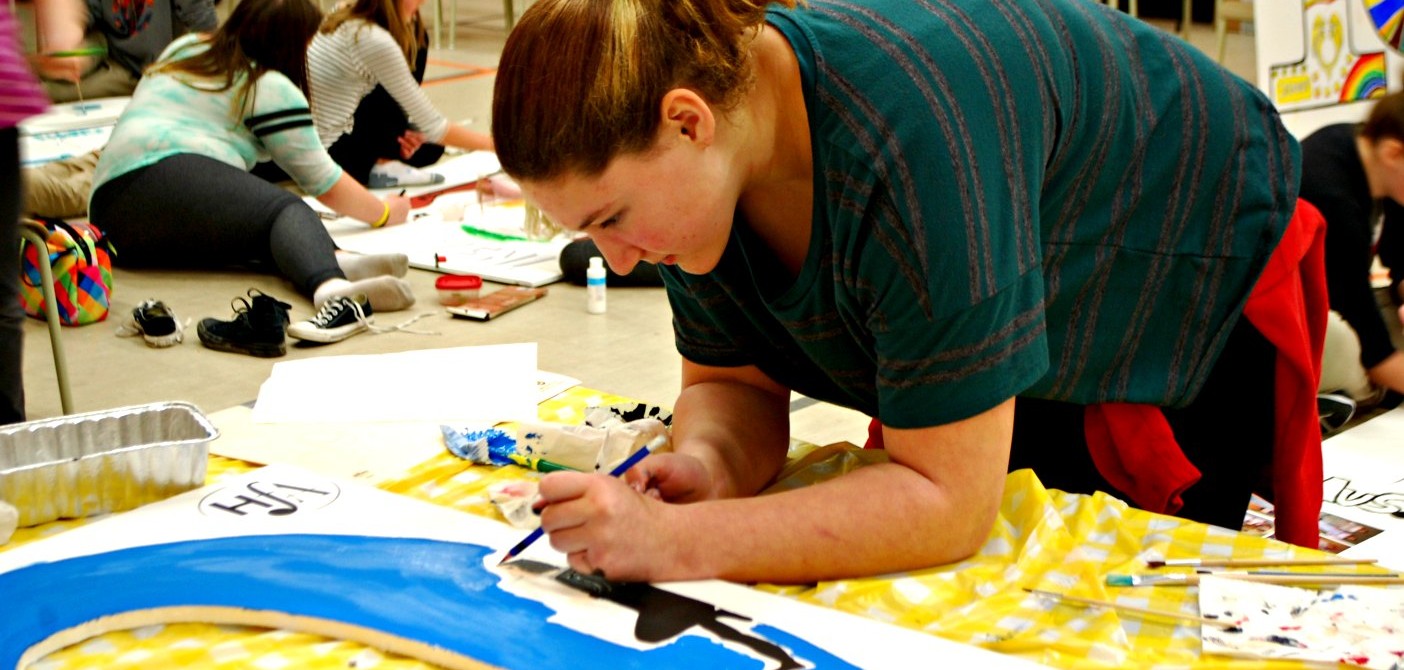 Riverside student Haley Brooks works on the fine details of a Guys and Dolls poster