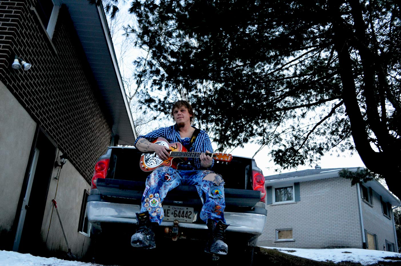 Jeff Stamp looks every bit a music man sitting on the back of his pick-up truck with his guitar.