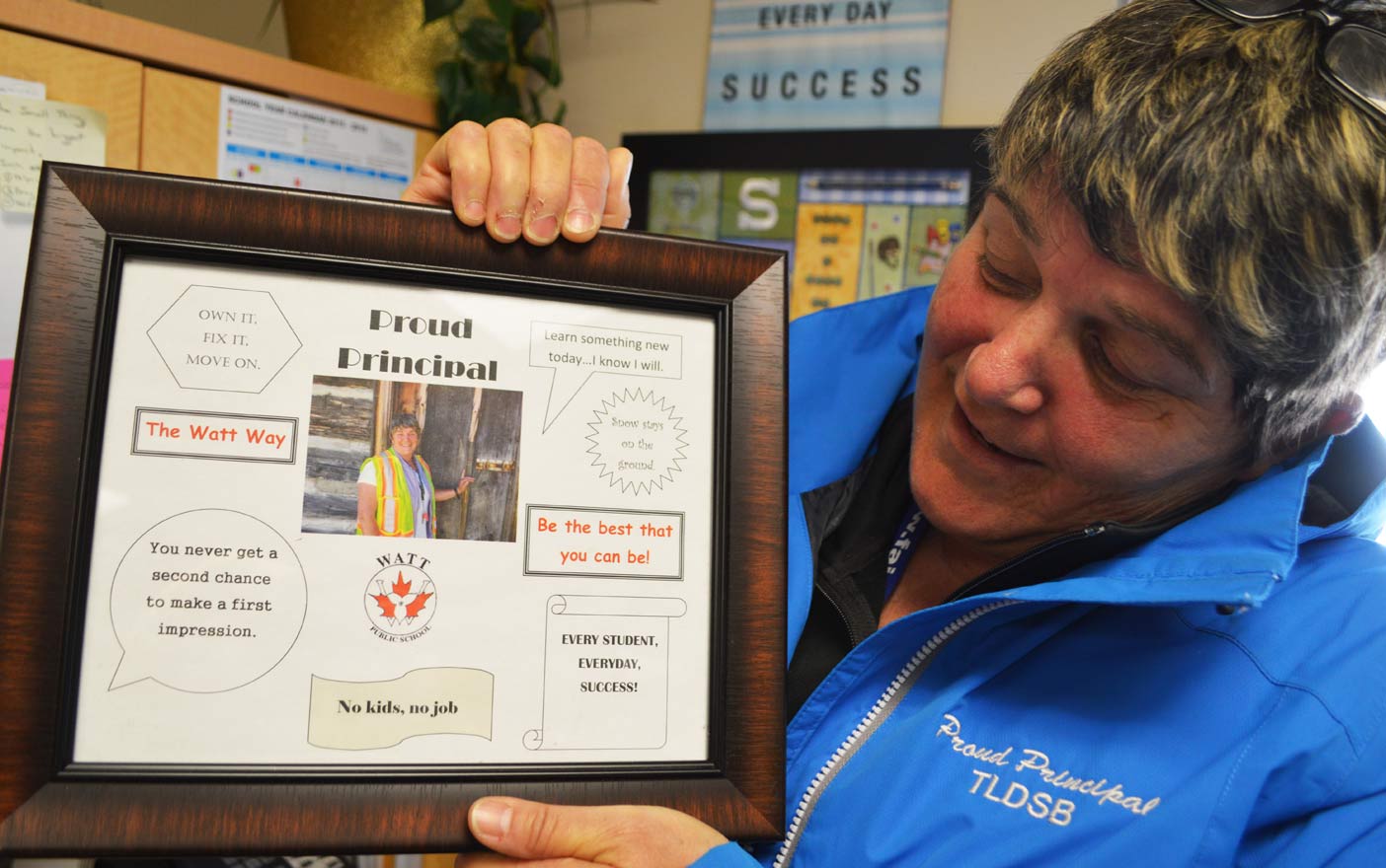She truly is a proud principal. Sharon holds a handmade picture that includes all her best sayings.