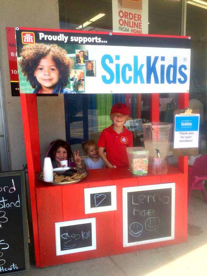 (From left) Neveah Green, Sofia Graham and Griffin Graham sell lemonade and cookies to passersby. (Photo: Christine Barkey)