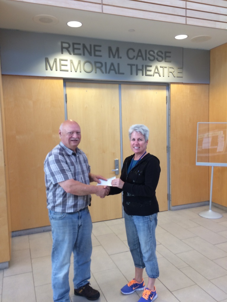 Derek Shelly of the Huntsville Trinity Drama Group presents a cheque for $1,000.00 to Tracy Hoehner, Technical Director of the Rene Caisse Theatre.