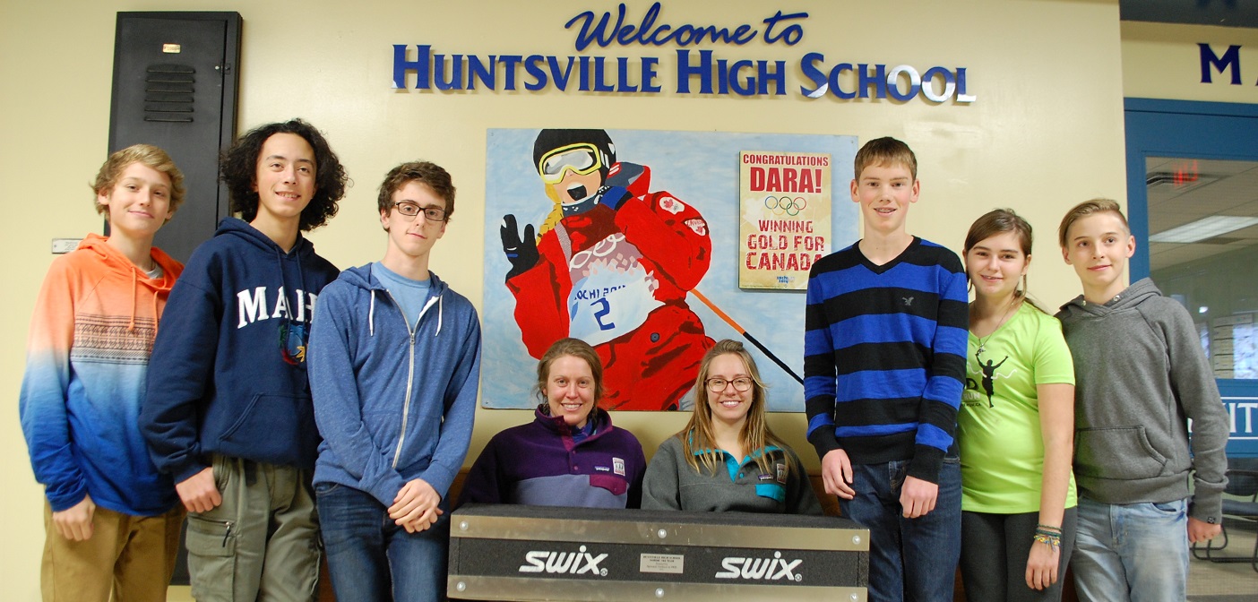 Carlee Wood (seated, left) and Candice Horton from Algonquin Outfitters present Nordic ski team members (from left) Erik Bertelsen, Keegan Chan, Aidan McClung, Owen Johnstone, Madeline Horton and Colin Welsh with a portable ski rack