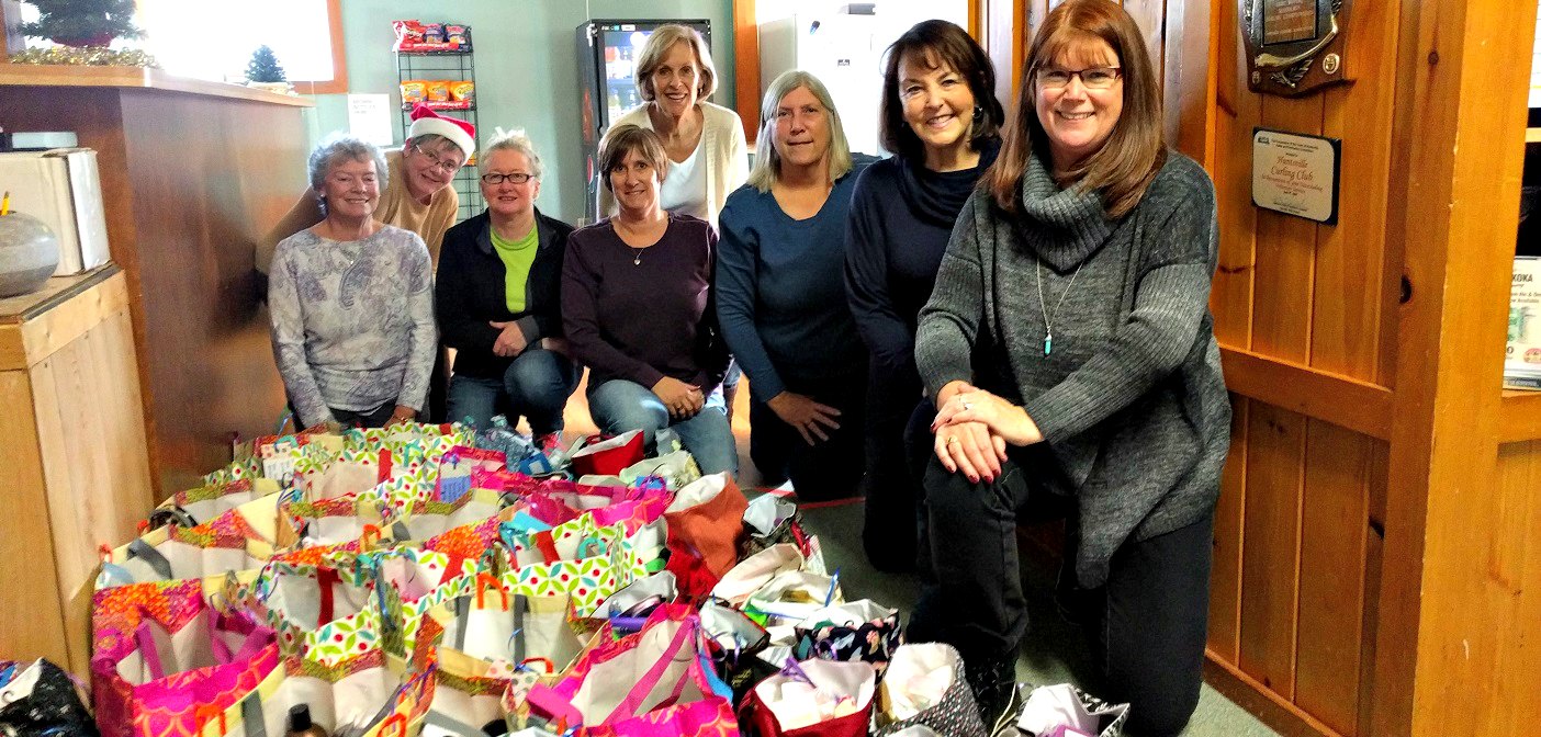 Volunteers (from left) Barb Saunders, Susan Bionda, Patsy Tousignant, Eileen Verdin, Jane Crockett,  Ann Maslen, Maggie Helwig, and Beth Goodhew with some of the assembled Hope Totes.  Missing: Carol Rocks, Angela Lytle, Beth Miller, Cathy Hurst, Barb Kavanagh, Barb Burton. (Photo courtesy of Beth Goodhew.)