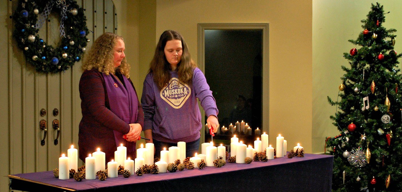 Samantha (left) and Julia Killingworth light candles in memory of the 33 women killed by violence in Ontario in the past year
