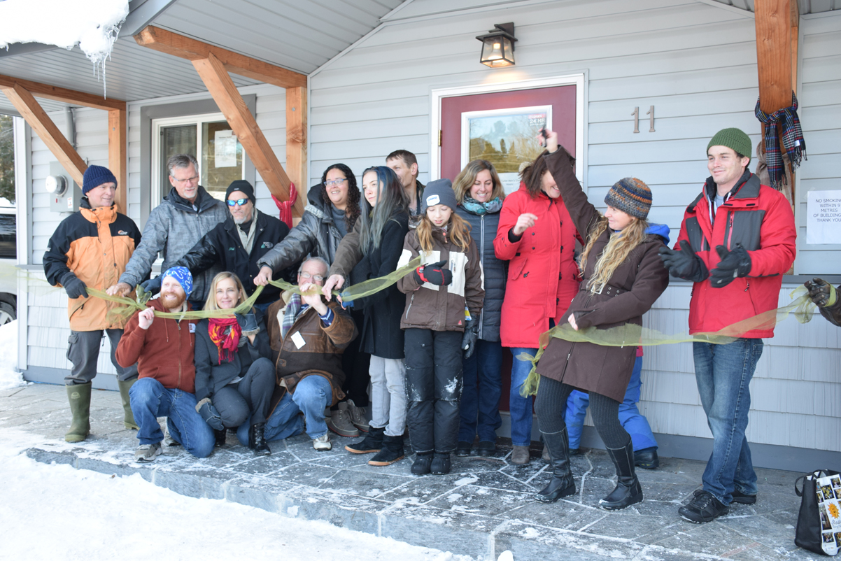 Heather Berg, second from right and fresh off the cut, is surrounded by friends, family, employees and  supporters of The Table Men’s Shelter at its official ribbon-cutting ceremony on December 10.