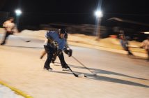 A player breaks away with the puck. Watching the Friday night game under lights was nostalgic.
