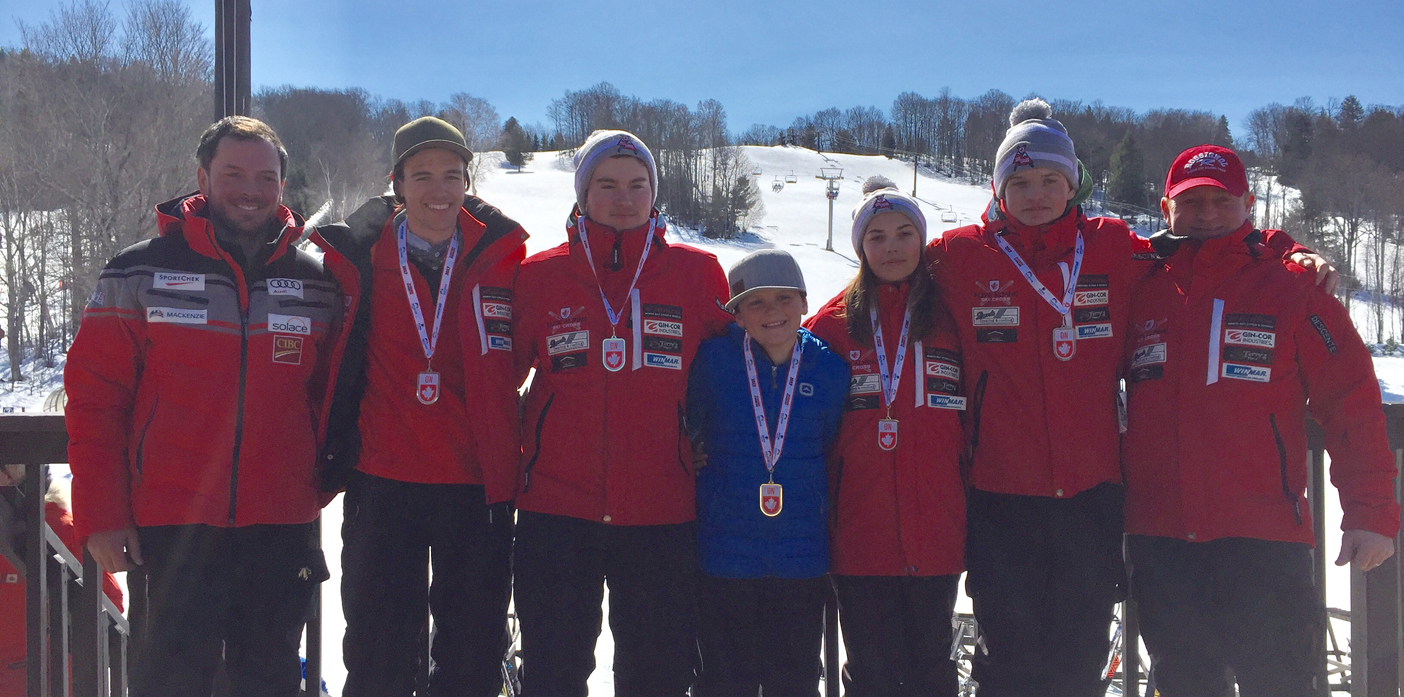 Andy Bulloch (centre) celebrates with members of North Bay’s Team Elite Snow Cross at the junior national championships
