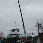 A crane lifted the old cabin onto a truck to be taken for disposal