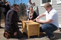 Teacher Jeff Brady (left) and students Elora Middleton and Nicholas Drewery seal the time capsule