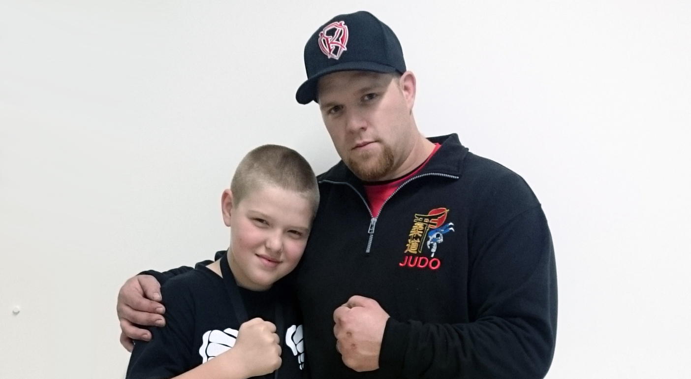 Jeff poses with his son, Lucas, after winning a silver medal in his return from a ruptured bicep suffered in December