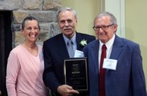 Larry Ireland (middle), who was inducted in the 'Athlete' category is welcomed by Hall of Fame members Jane Wolfe and Bob Adams.