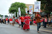 Participants in the walking parade carried signs denoting highlights of Huntsville's and Canada's history