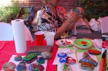 Rudi Stade focuses on painting a stone with plenty of inspiration from already completed rocks