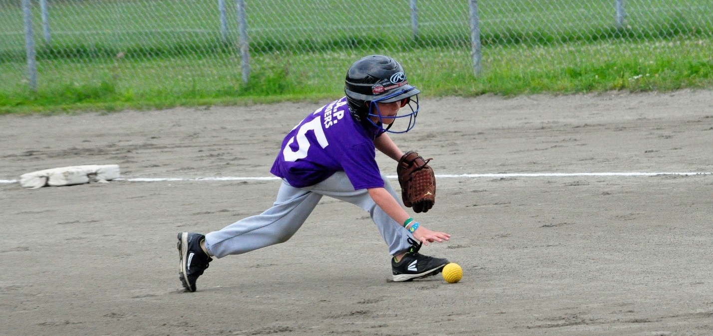 A player from the M.A.P. Stingers, a Muskoka Hornets house league team, picks up a grounder