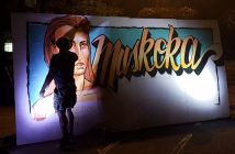 A spray paint artist creates a large-scale Muskoka-themed piece