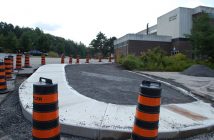 A sidewalk leads from the parking lot to a crosswalk next to the school. Previously, students had to walk on the road.