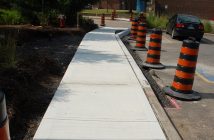 A new sidewalk leads from a crosswalk to Oliver's Coffee shop