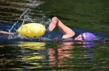 The swimmers wore purple Swim For Hospice caps