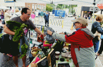 William Tajer buys a bunch of organic, locally grown beets from Diana Bechtel of Birchhill Farms.