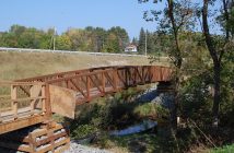 The new section begins with a pedestrian bridge at the end of East Airport Road