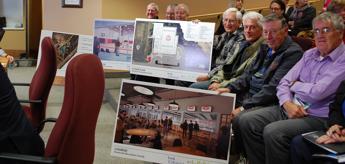 Members of the Huntsville Curling Club hold up artist’s renderings of the proposed multi-use facility at McCulley Robertson