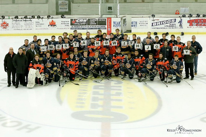 Otters and Flyers players put their on-ice rivalry aside and hold a sign #WeStandWithJoey to show their support for Stayner Siskins player Joey Visconti who was diagnosed with testicular cancer (Photo: Kelly Tomlinson)
