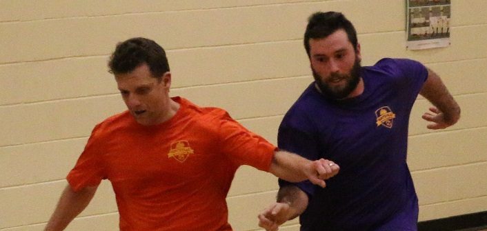 Ted Maduri of Orange Crush fights off Paul Borbeau of Crushed Grapes during Huntsville Indoor Soccer League action on Monday, Dec. 18 at Huntsville High School (supplied photo)