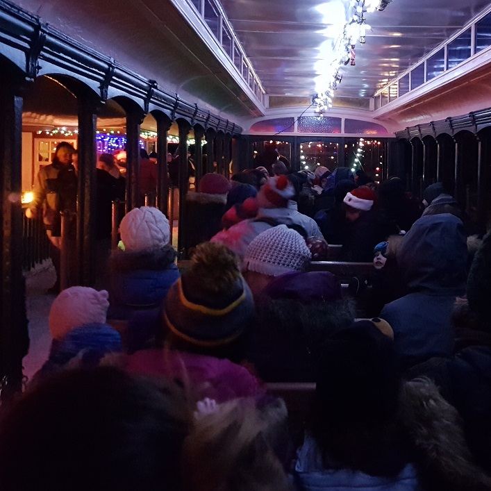 The historic open-air train cars are full of holiday spirit