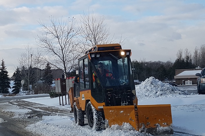 A Town of Huntsville sidewalk plow gets to work after a December snow squall passed through