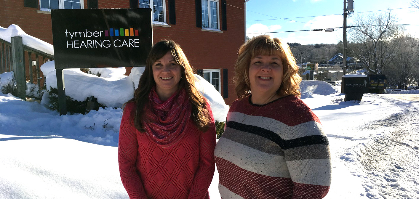 Andrea Fisher, owner, and receptionist Tina Schnurr in front of the Tymber Hearing Care office on Elm Street
