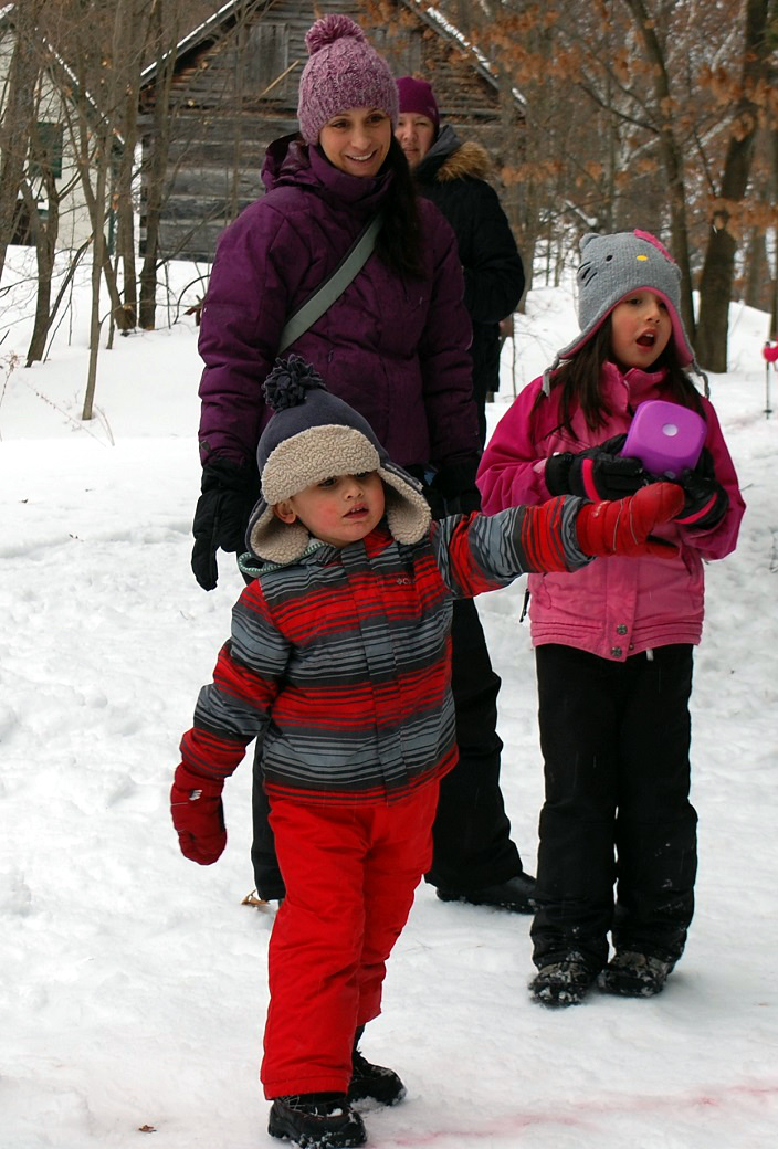 Keegan Gant (left) launches a dart toward the Olympic rings as his mom Adele and sister Serenity Gant cheer him on