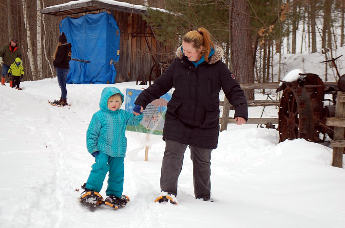 Olivia (left) and Sarah Elliott go for a snowshoe hike around the Pioneer Village. The snowshoes were on loan for the day from Huntsville Public School.