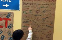 Kelly Miller checks out some of the student signatures on the pledge banner