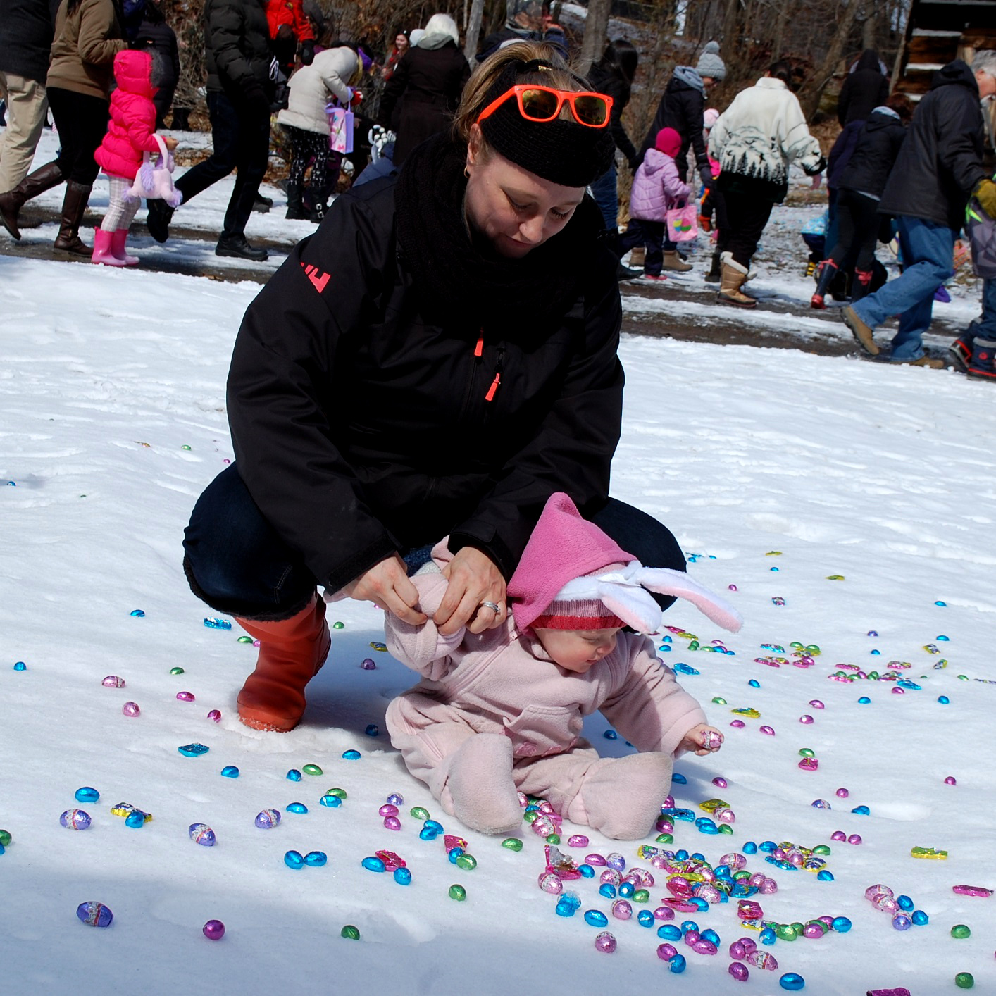Vixen Bennett, 13 months, wasted no time finding a chocolate egg while mom Katherine Andersen takes off her mitts