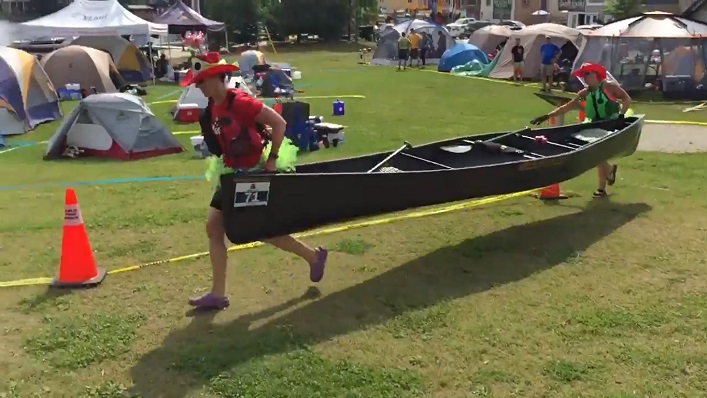The best dressed team? Red Planet Paddlers runs through the portage to begin another lap (Photo: @muskokariverx / Twitter)