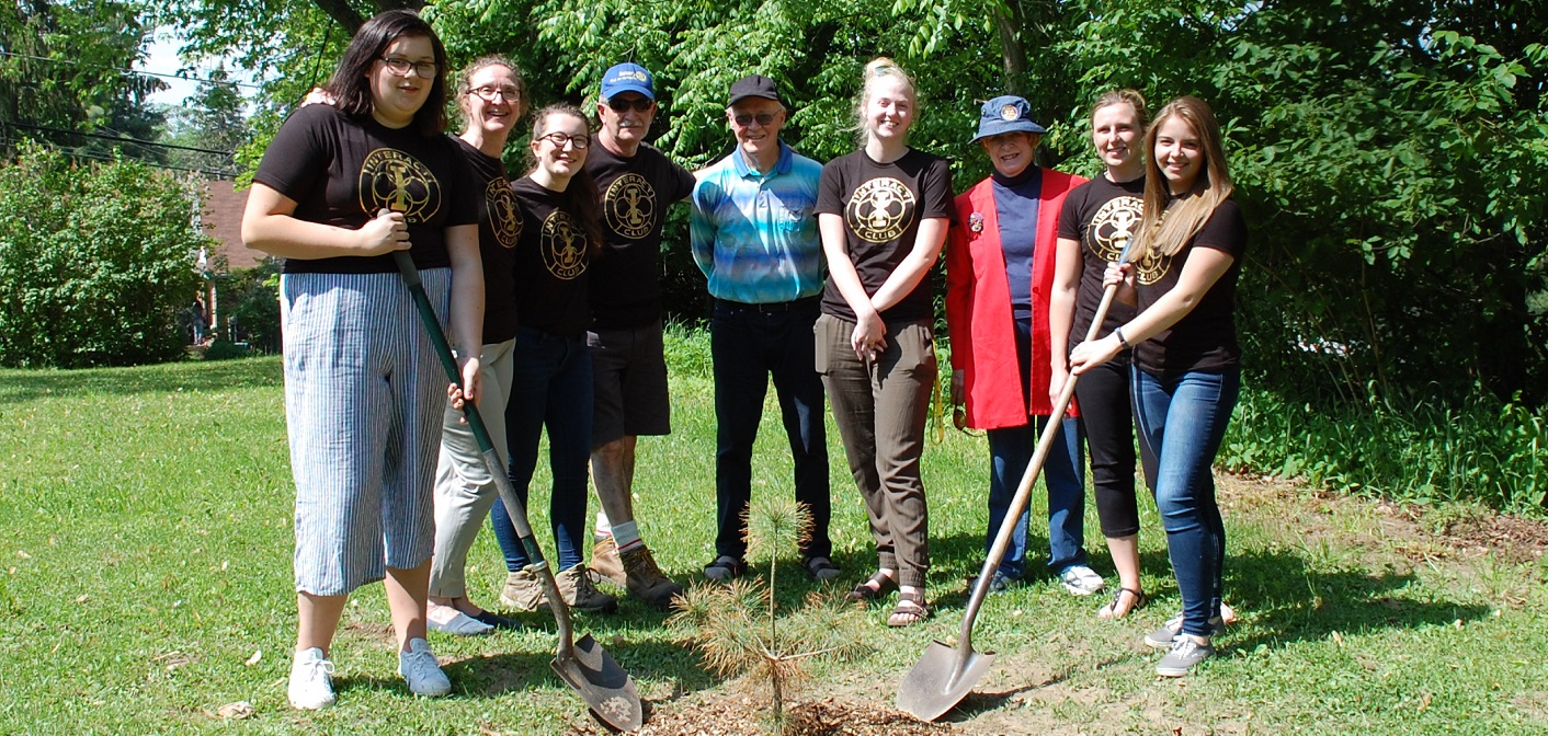 Members of the HHS Interact Club and the Rotary Club of Huntsville plant a legacy tree at the high school