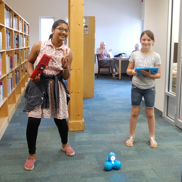 Haritha Ramachandran (left) and Zoey Harrison have fun with robots