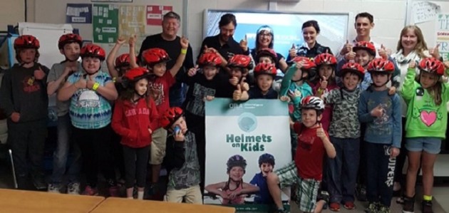 Local injury firm donates bike helmets to kids in support of brain injury awareness month