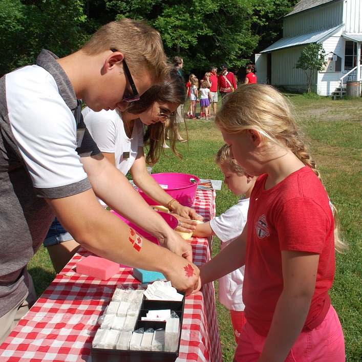 (Clockwise from left) Dylan Welsh and Alessia Ascenz give Max and Ella Dussault some cool Canada Day tattoos
