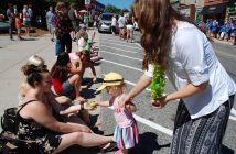 A young CORE Health volunteer shares an apple with a spectator (Photo: Dawn Huddlestone)