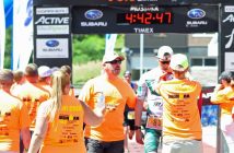 Volunteers at the finish line provide water and medals for the athletes