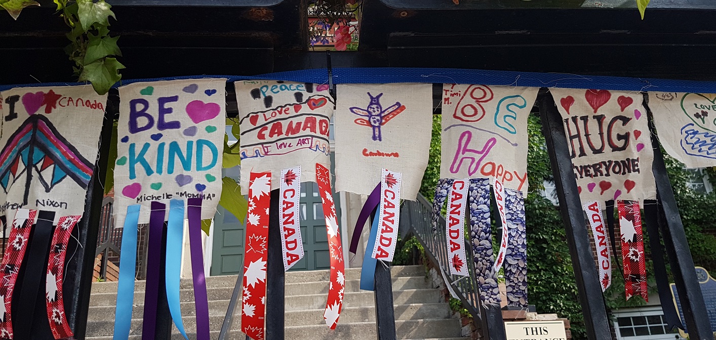 A peace flag, some of which is pictured here hanging at Town Hall, was created during Nuit Blanche North