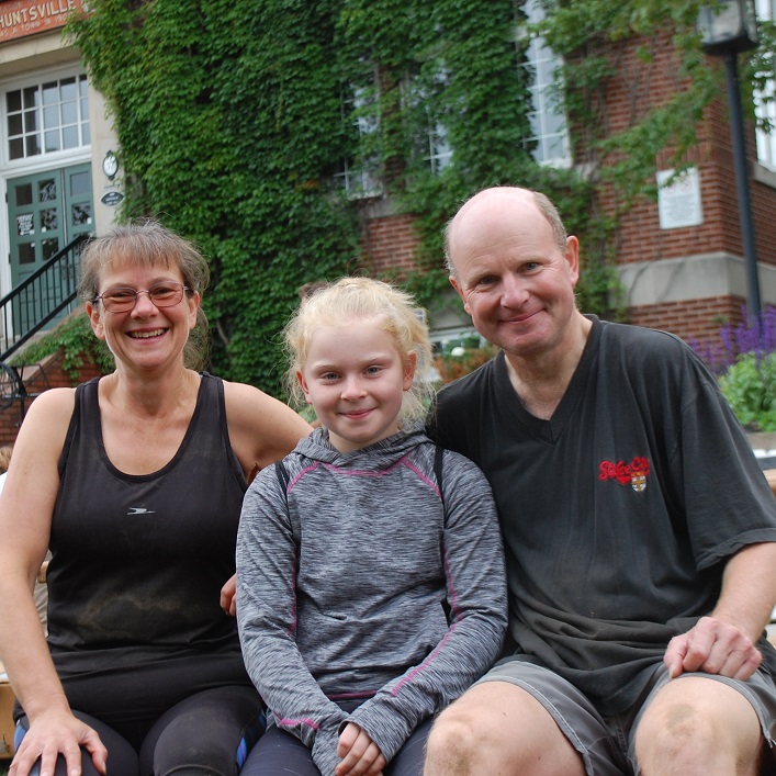 The Surman family (from left) Sue, Samantha and Neil from the UK took a break from their vacation to help lay sod