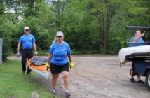 Volunteers Paul and Anne McKinnon help carry the boats to the beach launch.