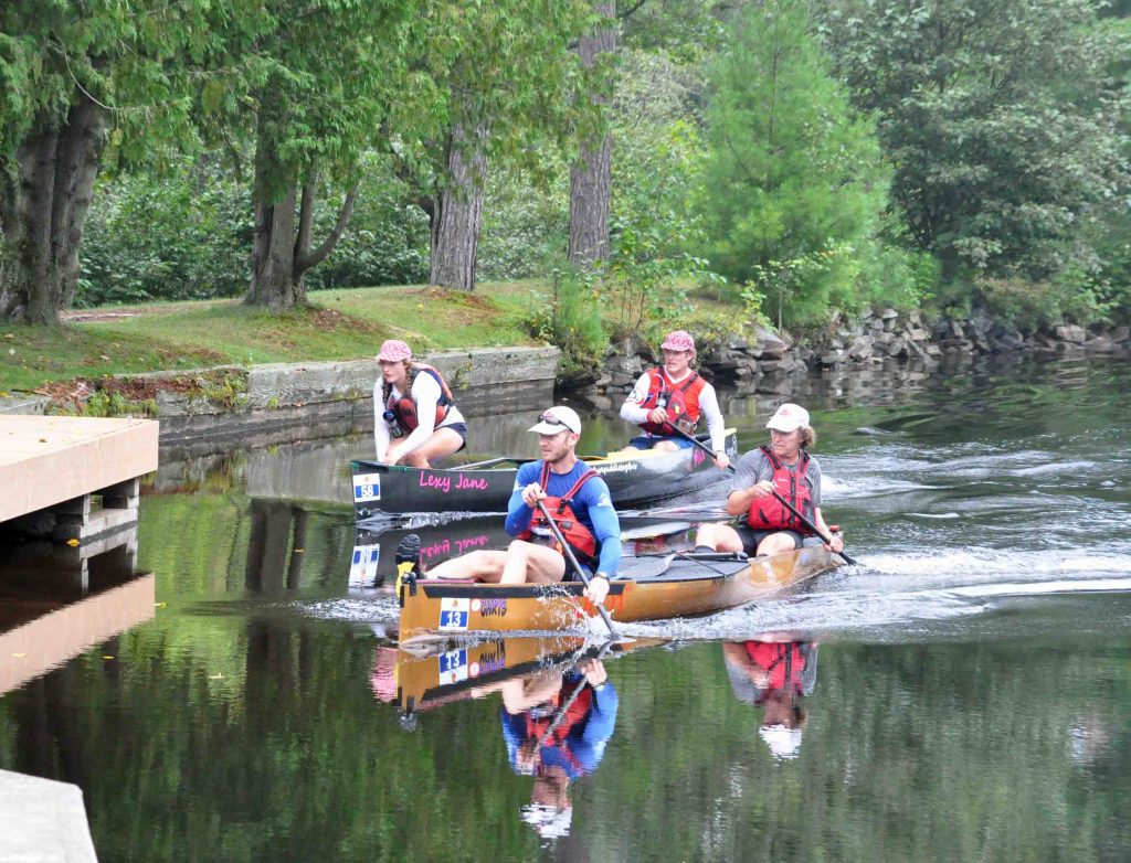 Eventual first place teams #wepaddletogether (Sprint), back, and Brace or Bust (Classic) paddle hard to the portage at the Brunel Locks Photo Cheyenne Wood