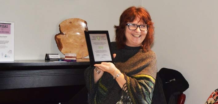 Lauren Power, executive director of Muskoka Parry Sound Sexual Assault Services (here displaying a recognition plaque for a MPSSAS program) is part of an OPP regional review committee for sexual assault investigations (Doppler file photo)