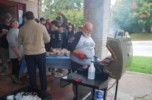 Dave Wyville grills burgers and hot dogs while Mayor Scott Aitchison serves them to students